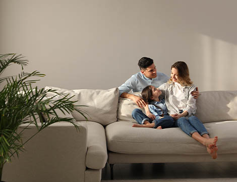 Photo of a modern living room with family sitting on a sofa chatting