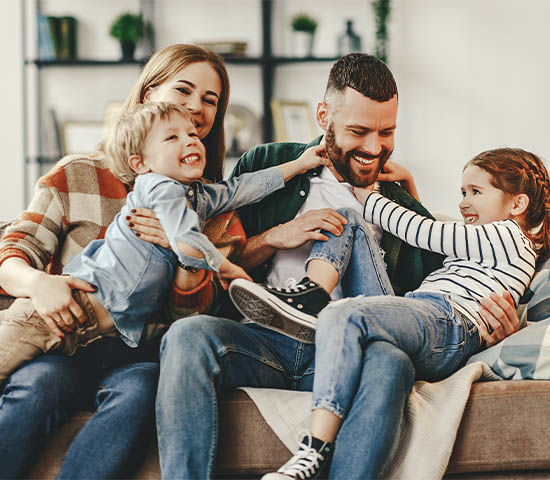 Family on a couch in a living room laughing together