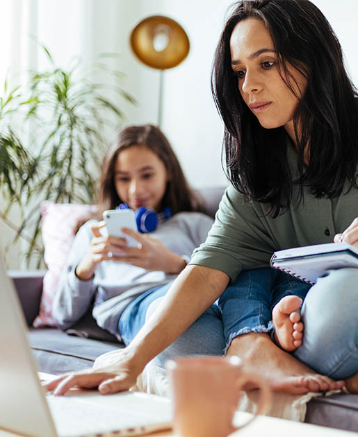 Lady on a laptop sitting next to a child